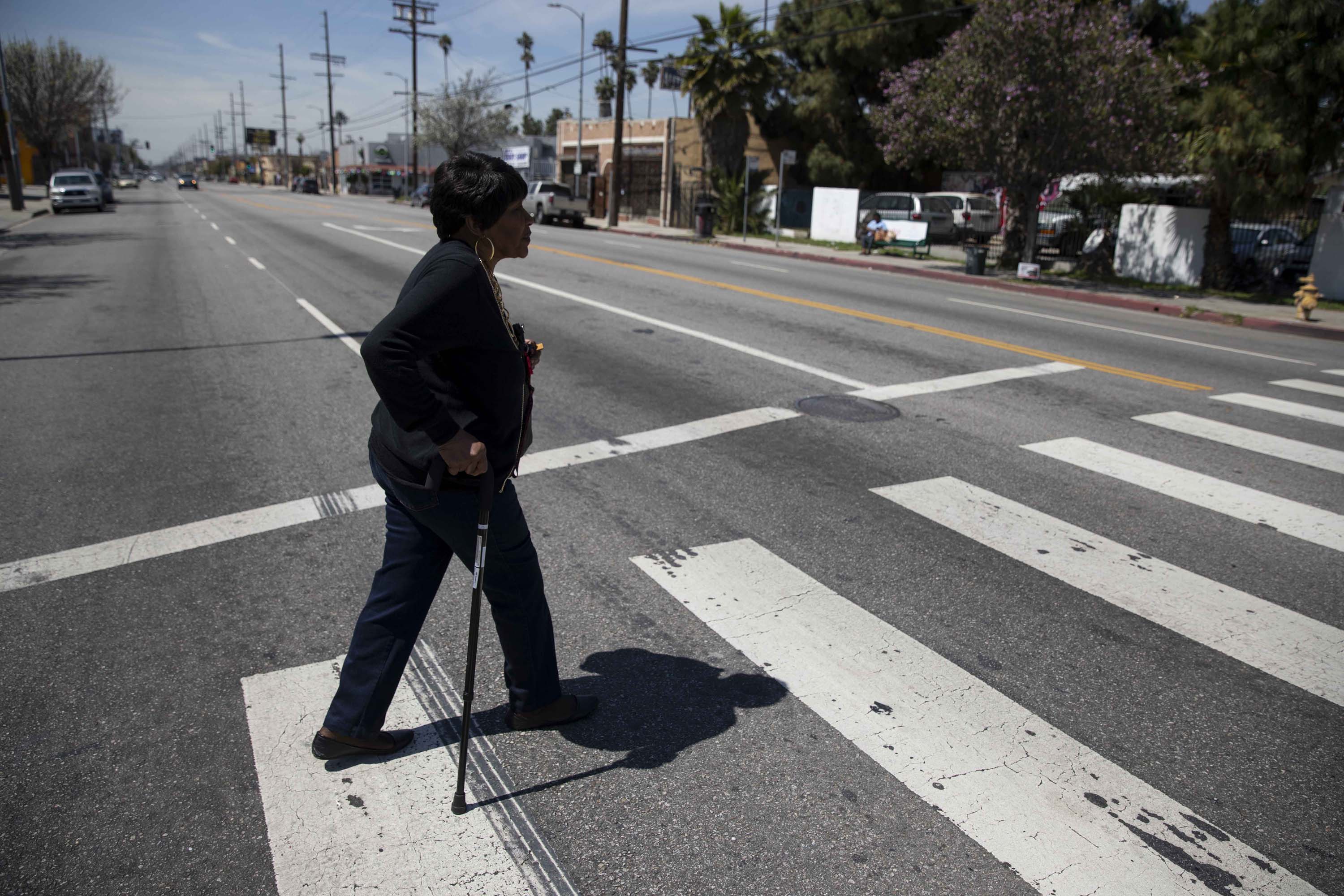 Emma Allen crosses the street near the South Los Angeles senior center where she works as a receptionist as part of a job training program for low-income seniors.