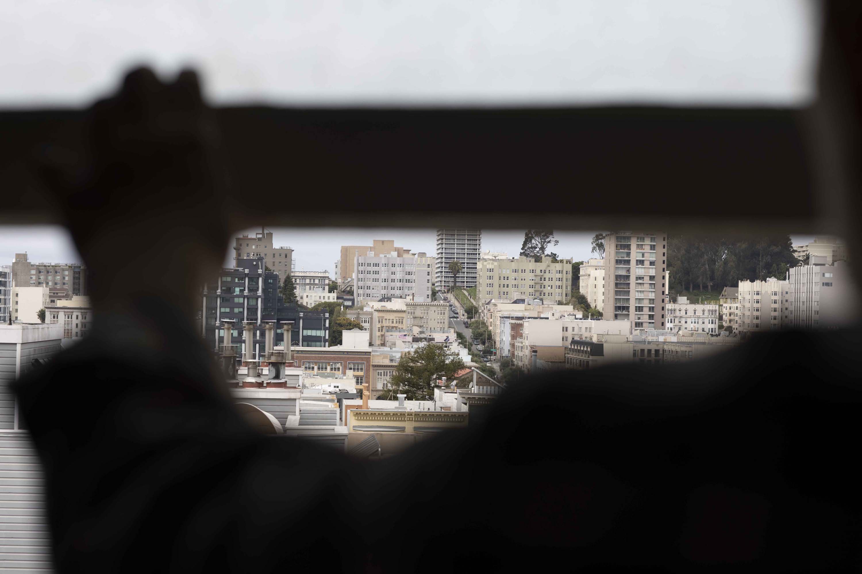 Emam Saber looks out the window of the modest apartment he cooks community meals of out several times a week. He and his wife are longtime residents of the Nob Hill neighborhood in San Francisco.